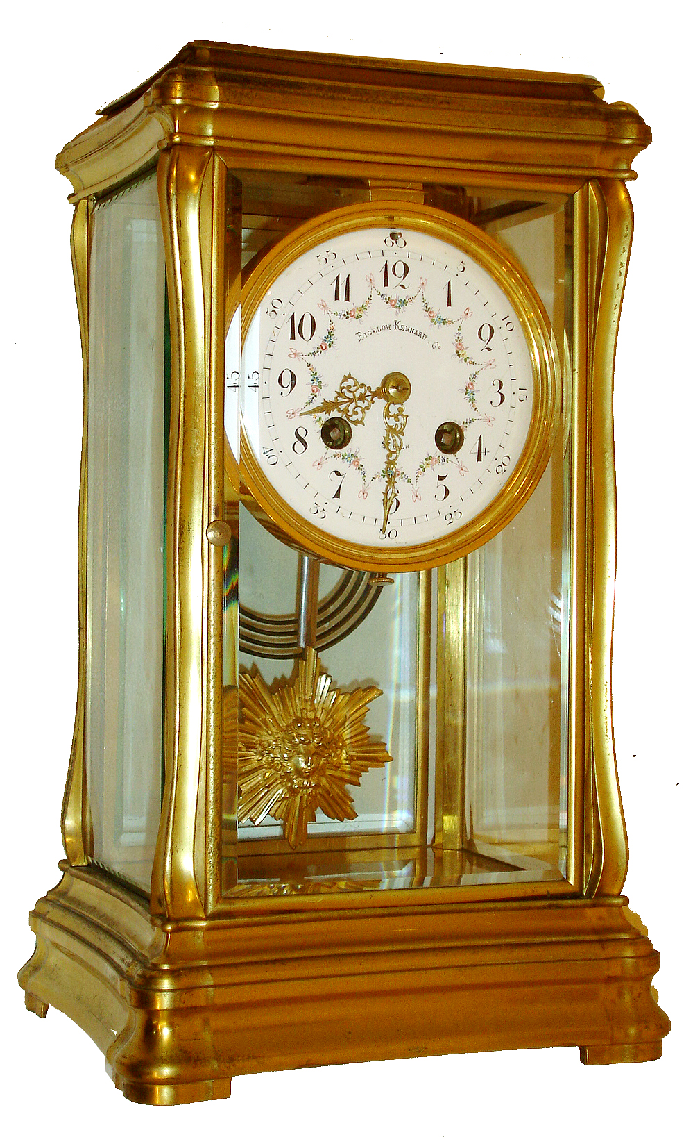 French crystal regulator for Bigelow, Kennard &amp; Co., Boston, gilt brass case with subtle Art Nouveau styling, the top and base with gently incurved sides, and with moldings similar to a Gorge style carriage clock, beveled glass panels, Arabic numeral white enamel dial with polychrome floral swags, gilt Louis XV style hands, gilt sunburst pendulum with mask, 8 days, time and strike, Pendule a Paris movement with Brocot escapement, and marked Japy Freres, c1900 — Antique Clocks Price Guide