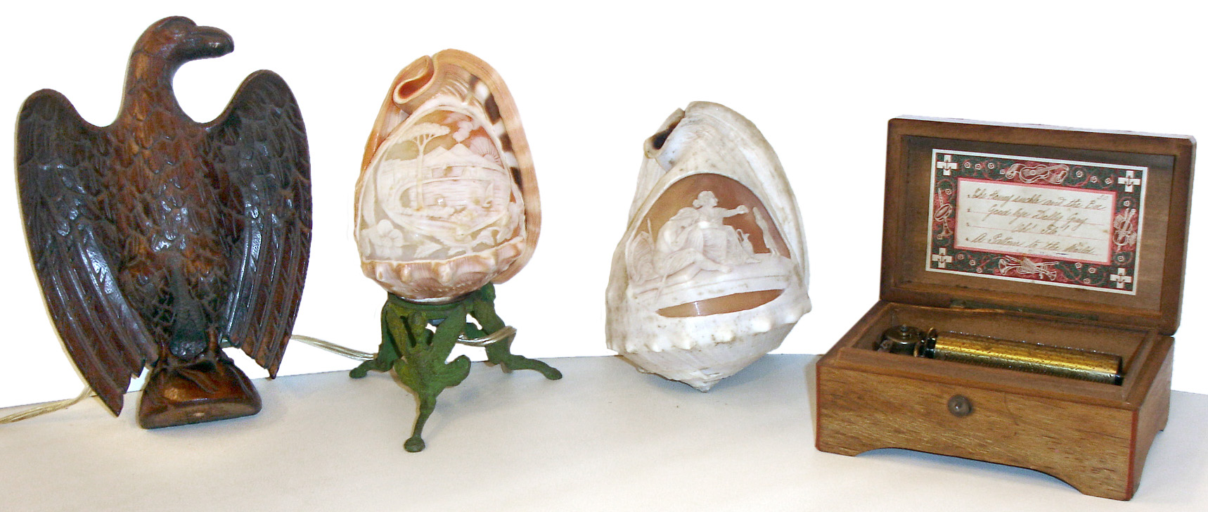 Mixed lot, two Victorian cameo carved shells, one made into a lamp, a carved mahogany eagle, and a small Swiss 4 tune music box — Antique Clocks Price Guide