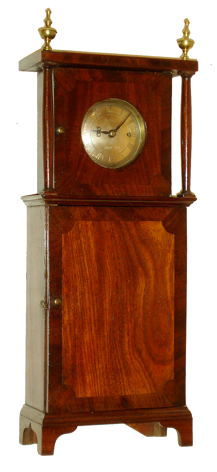 Grafton mantel clock, in the style of Simon Willard, c1900, two days, time only, weight driven movement in a mahogany veneer case with convex solid brass silvered dial signed Simon Willard.  James Conlin of Boston reproduced these 30 hours Willard, Grafton wall clocks about 1910 and is a good candidate for attribution. — Antique Clocks Price Guide