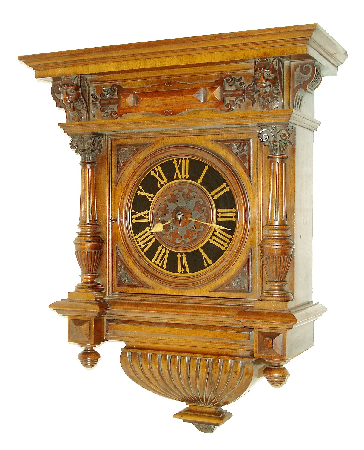 Austrian wall clock in and extremely ornate Victorian walnut case, reeded bottom with molded and carved drop, door with turned molded bezel with carved corner pieces, tapered, fluted columns with reeded vasiform bases and carved capitals, the frieze with carved masks, corbels, and applied ornament below a molded top, case back stamped "Anton Schlesinger Wien", Roman numeral painted metal dial, gold painted hands, 8 days, time and strike, Viennese style movement with silk thread escapement, c1880 — Antique Clocks Price Guide