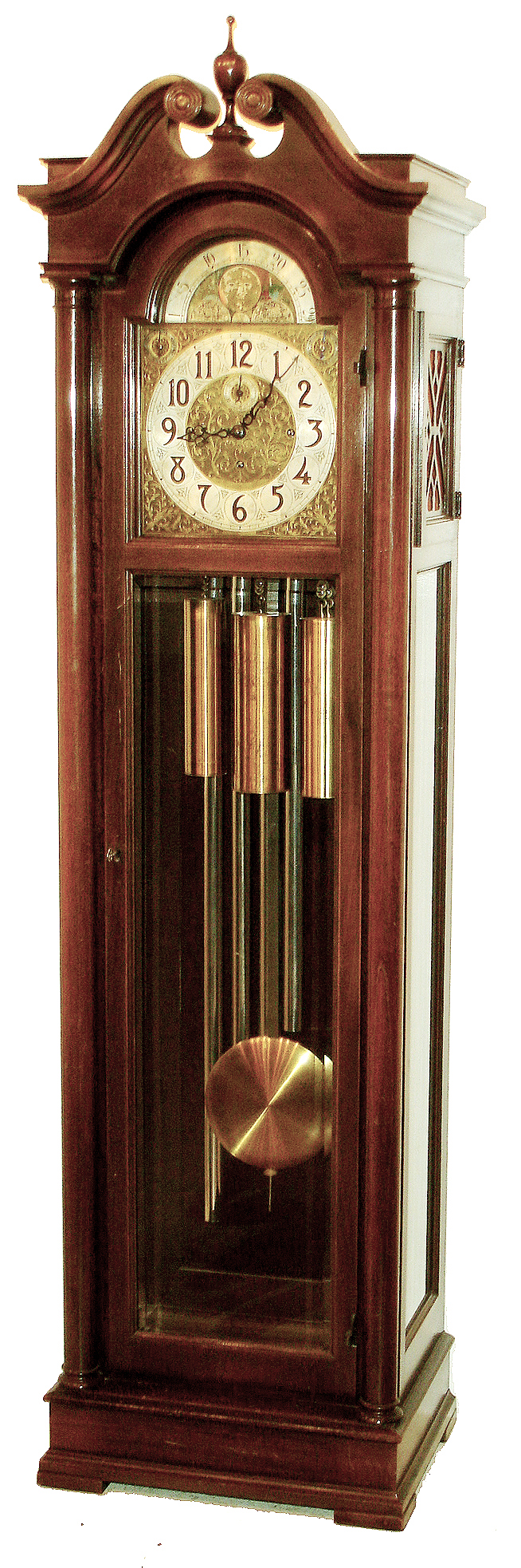 Colonial Manufacturing Co., Zeeland, Mich., tall clock, 8 days, time, strike and Westminster chime, three brass weight driven, large Winterhalder Hofmeier German movement in a mahogany case with beveled glass door and broken arch top. The silvered brass dial has applied numerals, moon phase, strike &amp; chime silent selectors, and brass spandrels, c1910 — Antique Clocks Price Guide
