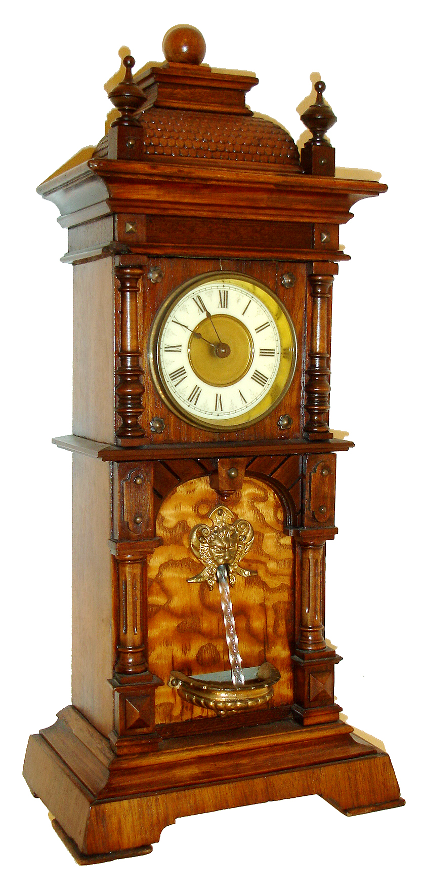 German, Novelty Waterfall or fountain clock. The miniature tall style case with timepiece movement at top, and a separate spring driven movement in the bottom, actuated at will to drive the twisty glass rod that simulates water, c1900 — Antique Clocks Price Guide