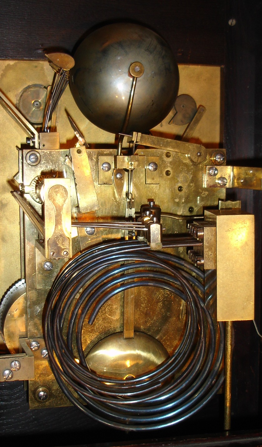 German, oak cased bracket or table clock, 3-fusee, 8-bell, by Winterhalder &amp; Hoffmeier. Chiming the quarters on choice of gongs (Westminster) or bells (Whittington), and with a rectangular dial with gilt cherub spandrels and subsidiary dials for time regulation and choice of tune, c1890 — Antique Clocks Price Guide