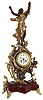 French figural mantel clock, red marble base with gilt scroll feet, the case with gilt and patinated rococo style ornament, trailing vines and flowers, at right a putto holding a bird, the top with female figure, her head back and with outstretched arms, gilt bezel with beveled glass, Roman numeral white enamel dial, blued steel hands, 8 days, time and strike, Pendule a Paris movement, c1890