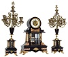 France, 3 piece mantel garniture, black slate drumhead case with columns and inset contrasting marble panels, the case front with beveled glass, applied gilt spelter ornament and animal paw feet, Arabic numeral white enamel dial with sunken center, signed "Philippe & Boisseri Rouen", Brocot open escapement, blued steel hands, 8 days, time and strike, Pendule a Paris movement signed Marti, faux mercury pendulum, with two candelabras of matching materials, design and ornament, c1880