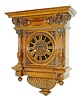 Austrian wall clock in and extremely ornate Victorian walnut case, reeded bottom with molded and carved drop, door with turned molded bezel with carved corner pieces, tapered, fluted columns with reeded vasiform bases and carved capitals, the frieze with carved masks, corbels, and applied ornament below a molded top, case back stamped "Anton Schlesinger Wien", Roman numeral painted metal dial, gold painted hands, 8 days, time and strike, Viennese style movement with silk thread escapement, c1880