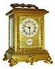 French repeating carriage clock with grand sonnerie striking, gilt case on scrolled feet with foliate ornament, ornate base molding, glass frames, and handle, case with beveled glasses, Roman numeral white enamel dial, the dark blue figures on pale blue grounds with gilt borders, and signed "Shreve, Crump, and Low Boston", dials with gilt mask with acanthus and c scroll engraving, blued steel hands, brass time, strike and alarm movement with lever platform, with lever to select grand or petit sonnerie, or silence, and repeating the last hour and quarter on demand, with travel case, c1890
