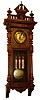 German, 3-weight grand sonnerie wall clock in a walnut porthole style case with pressed brass trimmings, and with engraved dial center, pendulum and weights, all matching with double tulips, striking the quarters on two long rods, c1890
