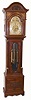 English tall clock, 8 days, time, strike and chime on 9 tubes playing two tunes, Westminster or Whittington, three brass weight driven movement in a cherry and veneer case with carved urn and paneled plinth, carved arch top and full columns with brass capitals flanking hood door. The brass dial has moon phase, silvered chapter ring, silence and tune selection dials, c1900
