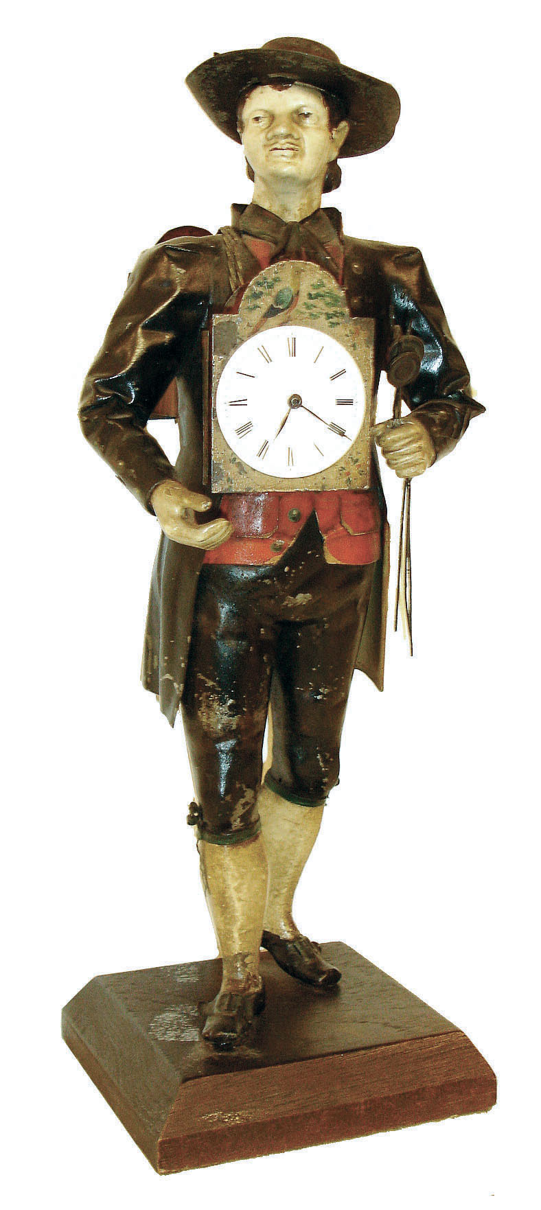 Germany, Black Forest "Uhrentrager" or clock peddler, the figure of polychrome painted sheet iron and in traditional dress, carrying a shield clock at his right fit with a Swiss lever escapement watch movement and dial, and with another clock slung over his back, his left hand clutching three pendulums, all mounted to a chamfered oak base, c1860 — Antique Clocks Price Guide