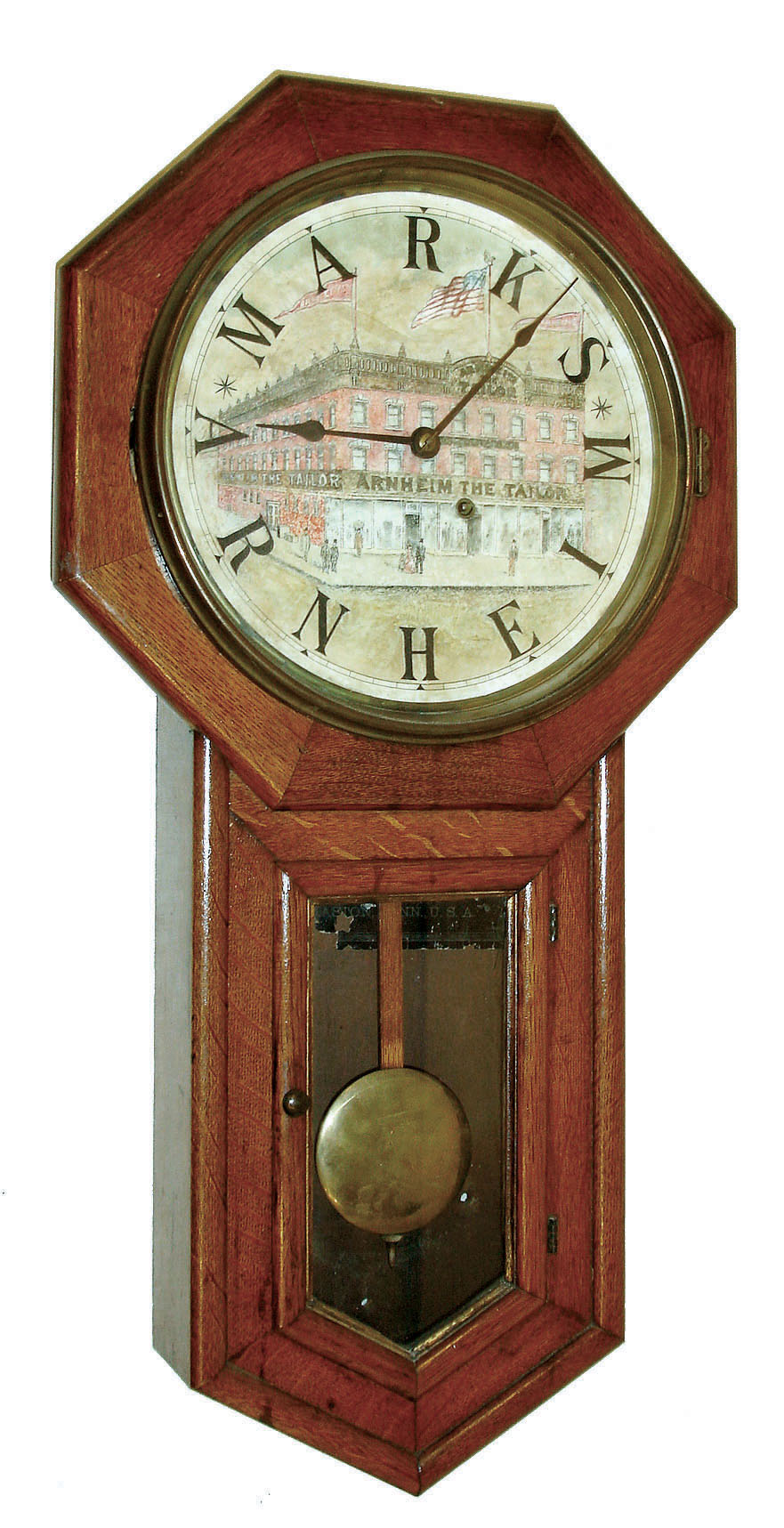 Seth Thomas Clock Co., Thomaston, Conn., "Globe" model 8 days, time only, drop octagon advertising wall clock in an oak case with personalized painted and hand colored advertising dial with a view of the establishment of "Arnheim the Tailor in the Manhattan's Bowery district 190, 192, &amp; 194 Bowery at the corner of Spring St." [New York] with "MARKS ARNHEIM" substituted for numerals 1 - 12, c1890 — Antique Clocks Price Guide