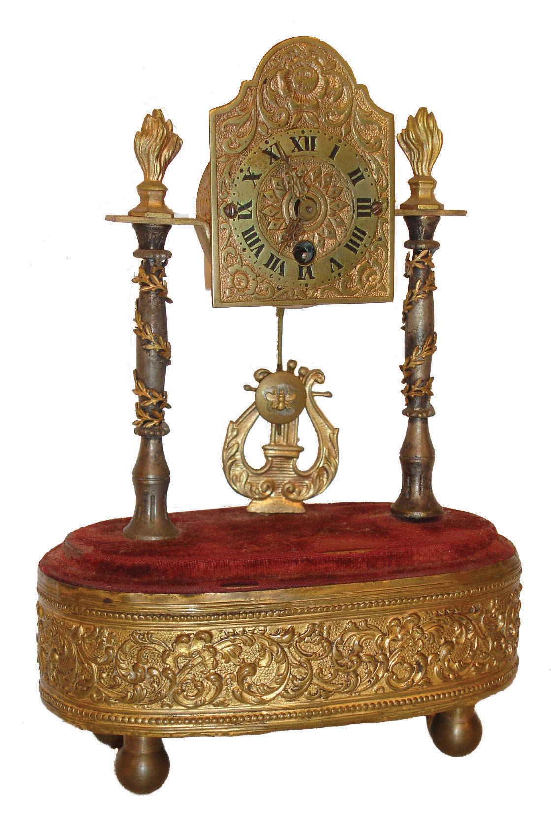 Hamburger, Vienna, Austria, small desk or table clock, 30 hour time only, movement with pin pallet escapement, case draws design inspiration from early 19th century Austrian mantel clocks, shield dial supported by two columns with foliate ornament and flame finials, base with repousse band and mounted to brass feet, music box concealed in the base and activated by pulling a cord at the left, c1900 — Antique Clocks Price Guide
