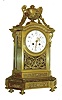 France, large gilt bronze mantel clock, with beveled glass sides, adorned with scrolls and swags in the Louis XVI style, the well made pendule a Paris movement bearing the imprint signature of Samuel Marti, the whole setting on a 16 sided base, with floral frieze, and surmounted by a large 2 handled urn draped to the base with floral swags, C.1900