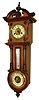 Hamburg American Clock. Co., Germany, small 8 days, time and strike, wall clock with barometer and thermometer, walnut case with molded cornice and mid section, door of inverted keyhole shape and containing a thermometer and aneroid barometer, the barometer with colorful enamel dial, thermometer with silvered scale, removable case top with broken arch and plinth with finial, case bottom also with drop, brass bezel with beveled glass, Arabic numeral white enamel dial, blued steel hands, engraved plaque with dedication below dial, c1895