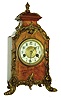 Hamburg American Clock Co., Germany, 8 days, time and strike, shelf clock in walnut veneered wooden case in the French style with applied cast foliate ornament, case top with small cast finial, brass bezel with beveled glass, Arabic numeral white enamel dial, blued steel hands, dated 1899 on label.