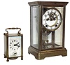 Clocks- 2 (Two).  American crystal regulator, brass case with beveled glass panels, 8 days, time and strike, movement, Arabic numeral white enamel dial with exposed Brocot escapement, faux mercury pendulum, and a French carriage clock, brass case with beveled glass panels, 8 day time and alarm movement, Arabic numeral white enamel dial