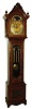 Seth Thomas Clock Co., Thomaston, Conn., tall clock, 8 days, time with quarter chimes on four bells and hour striking on cathedral gong, triple weight driven movement in a quarter sawn carved oak case with beveled trunk door glass and carved and turned full columns flanking hood.  The brass dial has applied cast brass spandrels and engraved dial center, a silvered chapter ring with applied brass numerals and moon phase, c1900