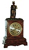 Winterhalder & Hofmeier, Germany, "King Gambrinus" drinker mantel clock, burl walnut case with ogee molded base and brass line inlay, Roman numeral silvered dial, blued steel hands, case top with carved, polychrome painted figure of King Gambrinus, patron saint of beer, the figure with his right foot on a barrel, and when activated, alternately raising a bottle to fill his glass, and then drinking the contents, the action performed twice at each activation, and occurring roughly every 6 minutes, brass 8 day time and swill movement, back of case with small engraved brass plaque marked "H. Rick Clockmaker New York", c1870