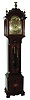 John Elliott, London, England for Bigelow, Kennard & Co., Boston, Mass., tall clock, time, strike and Westminster chime on cathedral gongs,  8 days, three brass weight driven movement in a mahogany inlaid case with floral motif on door and urn with flowers on base, both framed with herring bone inlay, Roxbury fretwork and brass capped full Corinthian columns on hood, three upper brass finials including center eagle finial, trunk door surmounted by clamshell carving and flanked by fluted quarter columns with brass caps and bases, all resting on a cutout skirt with ogee bracket feet.  The brass dial has ornately cutout and engraved brass corner spandrels and profusely engraved dial center silvered chapter ring with applied brass numerals, hour strike / silent and Westminster chime / silent selectors and moon phase dial, c1910