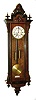 Gustav Becker, Freiburg, Germany, Vienna regulator, walnut veneered case with ebonized moldings and finials, and leaf carved corbels at the top and bottom of the door, stepped top also with a removable carved crest, Roman numeral white enamel dial with small seconds below 12:00, pierced blued steel hands, brass 8 day weight driven time and strike movement, brass weights, c1880