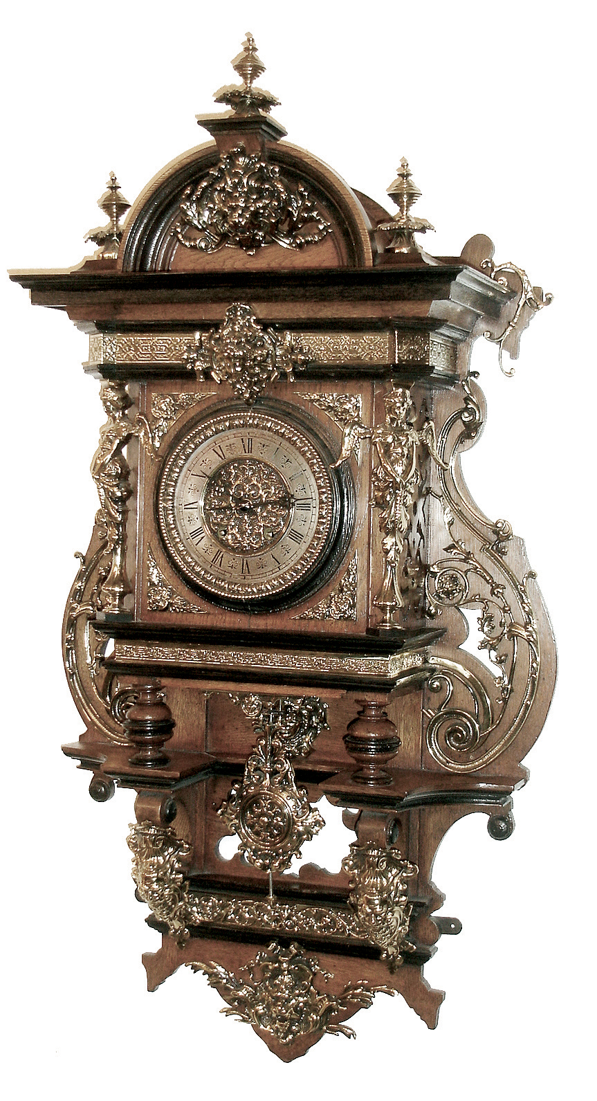 Lenzkirch, Germany, a very rare ÒFreischwingerÓ of oak and brass, with ebonized trim; large and impressive with cast and polished finials. There are full form winged maidens flanking the dial, and several cast faces of Northwind, Minerva and Diana, and the case sides with large swirls of cast brass. A very heavy item, Serial No. 427222, c1869 — Antique Clocks Price Guide