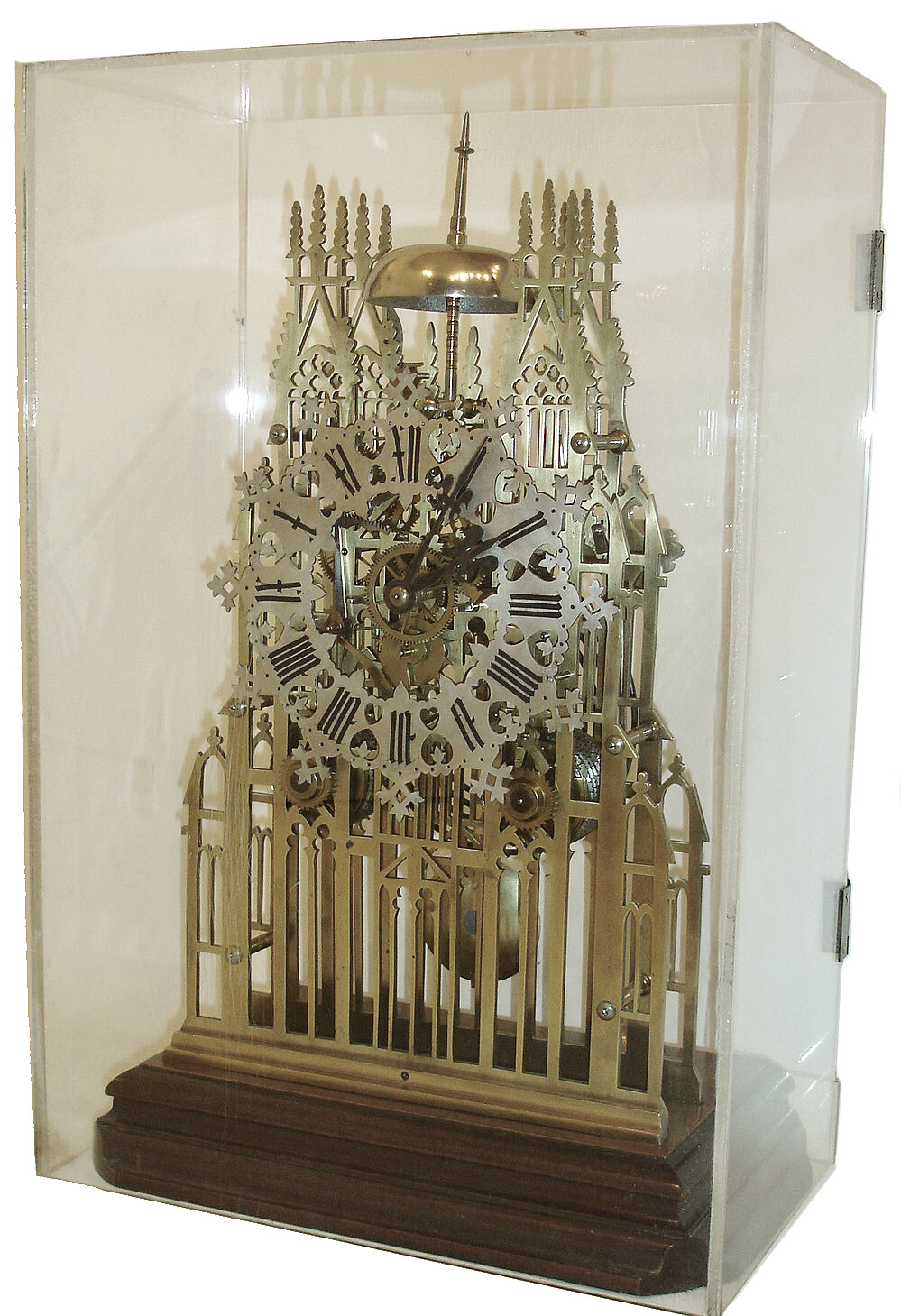 England, a large cathedral form skeleton clock, 7 turned pillars joining the intricately pierced plates, Gothic Roman numeral silvered dial with heart form piercing and scalloped edges, blued steel hands, 8 days, time and strike, fusee movement with recoil escapement, passing strike on a bell, and counting the hours on a large gong, all mounted to a molded mahogany base, the corners rounded to accept a glass shade, now with a Lexan enclosure, c1870 — Antique Clocks Price Guide