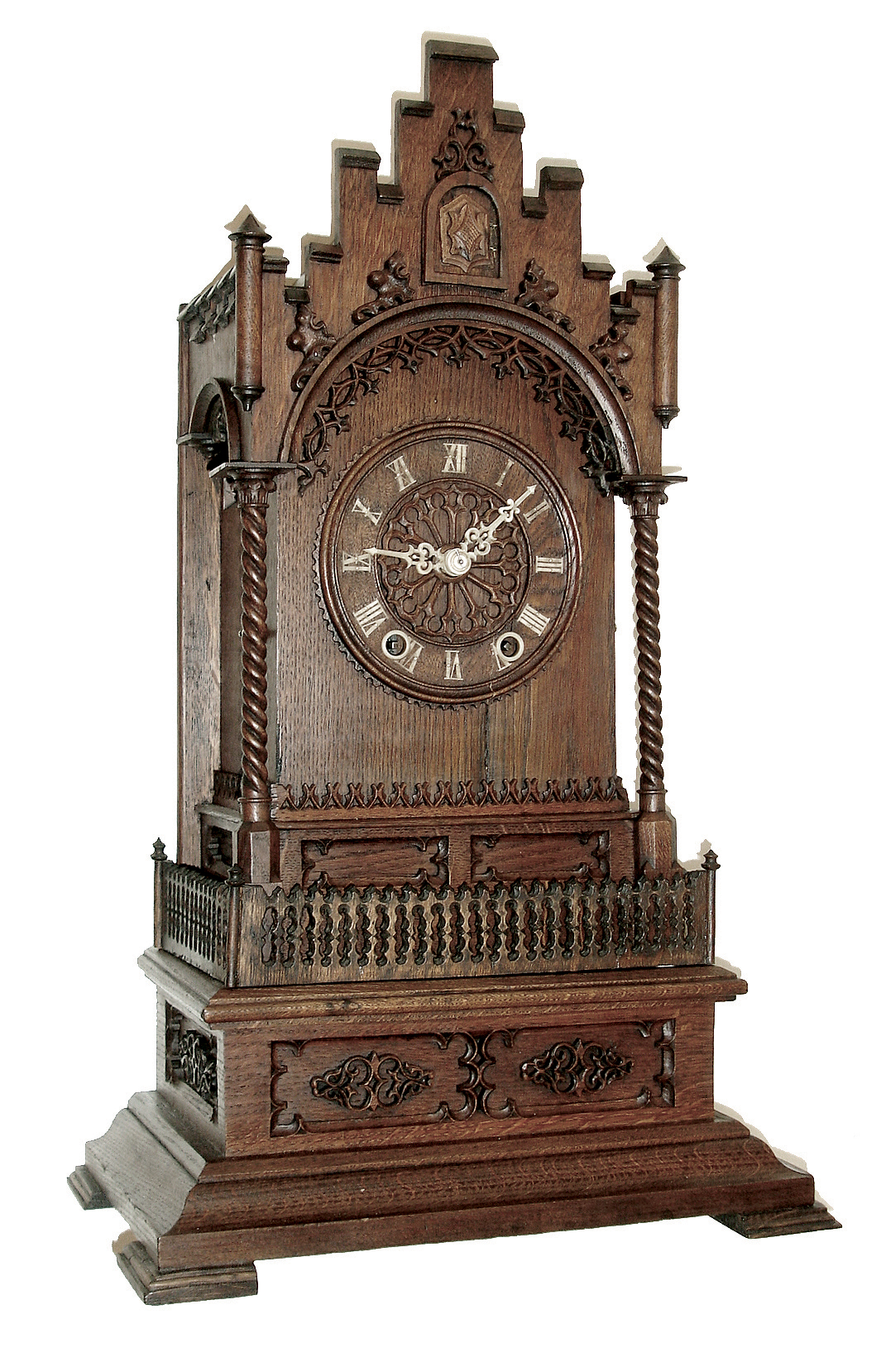 Germany, large shelf cuckoo, the Gothic inspired oak case of architectural form, with castellated parapet above a molded arch with applied, pierced carvings, supported by slender twist turned (barley twist) columns at the corners. The Roman numeral, turned wooden dial with carved hands, all on a rectangular base with carved, recessed panels, ogee molding, and flat, molded feet, 8 days, two train fusee movement striking on a gong assisted by the painted wooden cuckoo, c1860 — Antique Clocks Price Guide