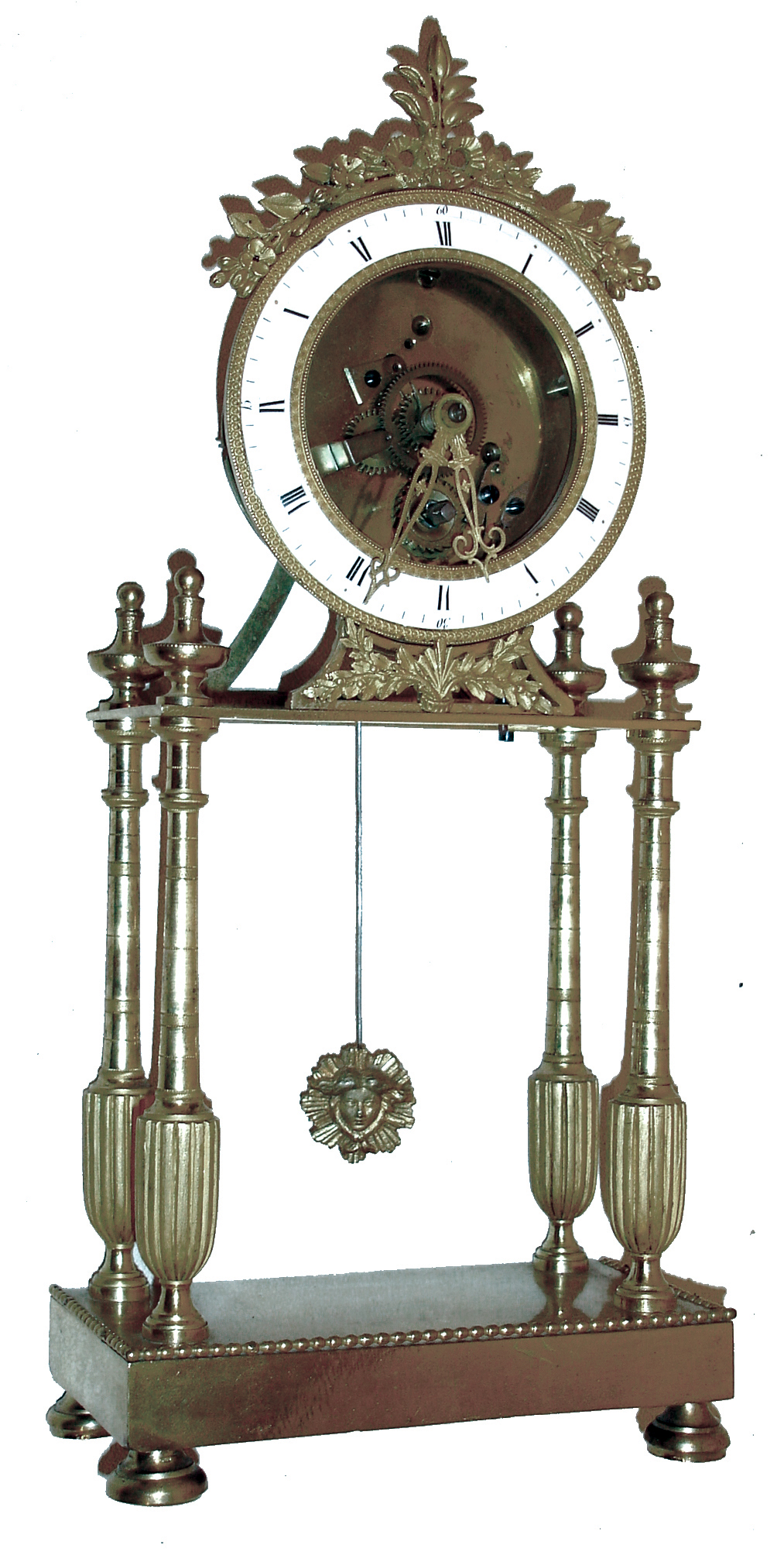 France, gilt bronze mantel timepiece, the oblong base with beaded molding and on turned feet, supporting four slender, tapered columns with reeded, urn form bases, and surmounted with turned urn form finials, the portico supporting the, 8 days, timepiece movement and skeletonized, Roman numeral white enamel dial, silk suspended pendulum with gilt Helios mask, and decorative pierced and chased gilt hands, c1800 — Antique Clocks Price Guide