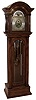 Elite, Germany, tall case clock, 8 days, time, strike and Westminster chime on nine tubes, three brass, weight driven movement in an antiqued birch case with full turned columns and beveled glasses. The brass dial with silvered chapter ring, moon phase, strike / silent and chime selectors, c1900