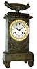 France, Empire period, bronze clock, 8 days, vertical monument motif surmounted by a large urn, and with silvered dial and gilt bezel, silk thread suspended pendulum on well made movement, c1830