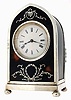 England, lancet arch-shaped desk clock, silver gilt frame on compressed ball feet, with London hallmark and date letter for 1907. The front and sides have tortoise shell panels and engraved silver inlay, Roman numeral white enamel dial, blued steel hands, French, 8 days, timepiece movement with lever platform
