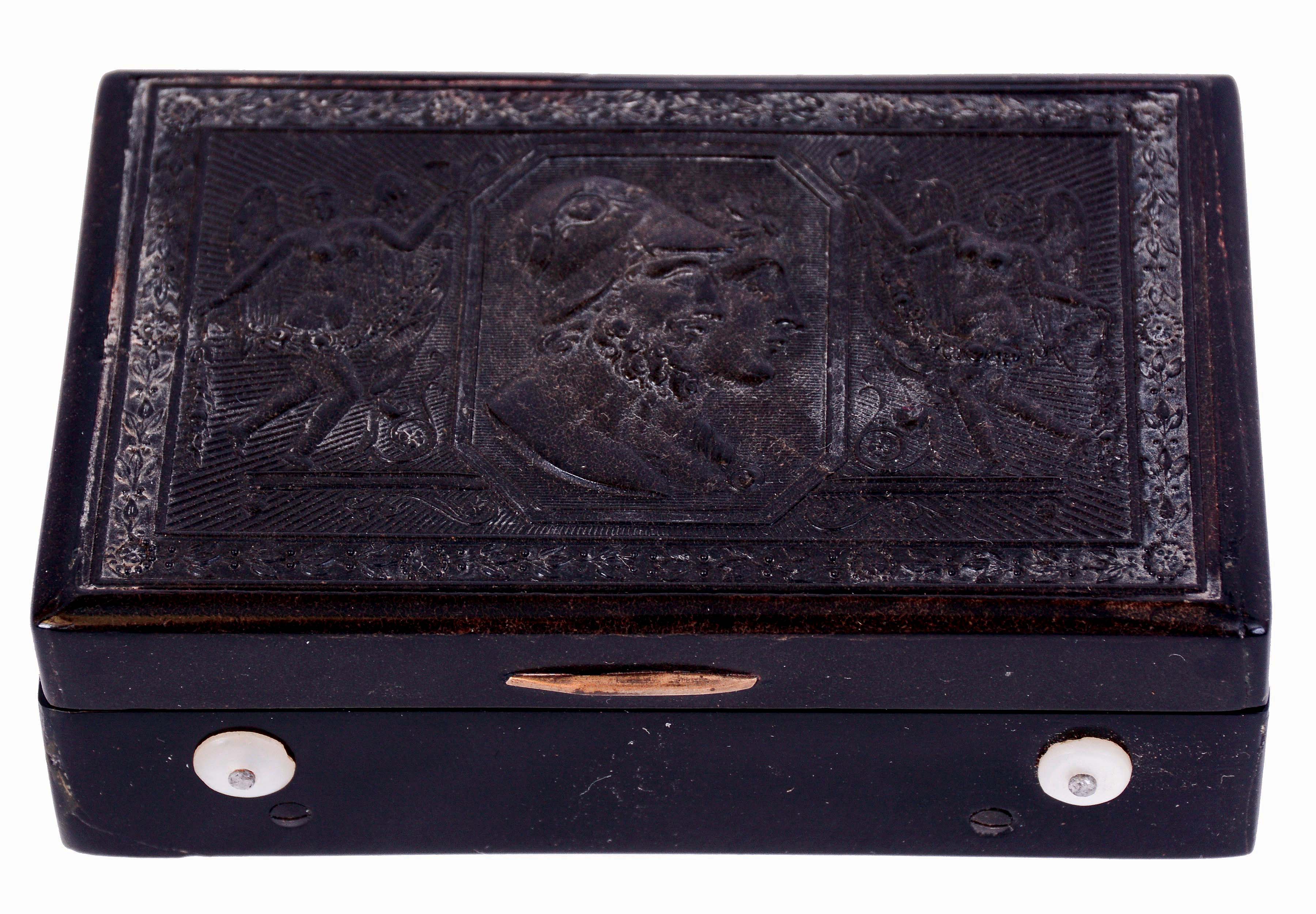 Switzerland, music box, rectangular case of tortoise shell and gutta percha, the top molded with Greek or Roman busts, flanked by winged figures bearing floral garlands, molded bottom with hobnail pattern, the mechanism playing two tunes, 2 1/2" cylinder with 14 section, 70 tooth comb, 3 3/4" x 2 3/8" x 1 1/4", 19th century — Antique Clocks Price Guide