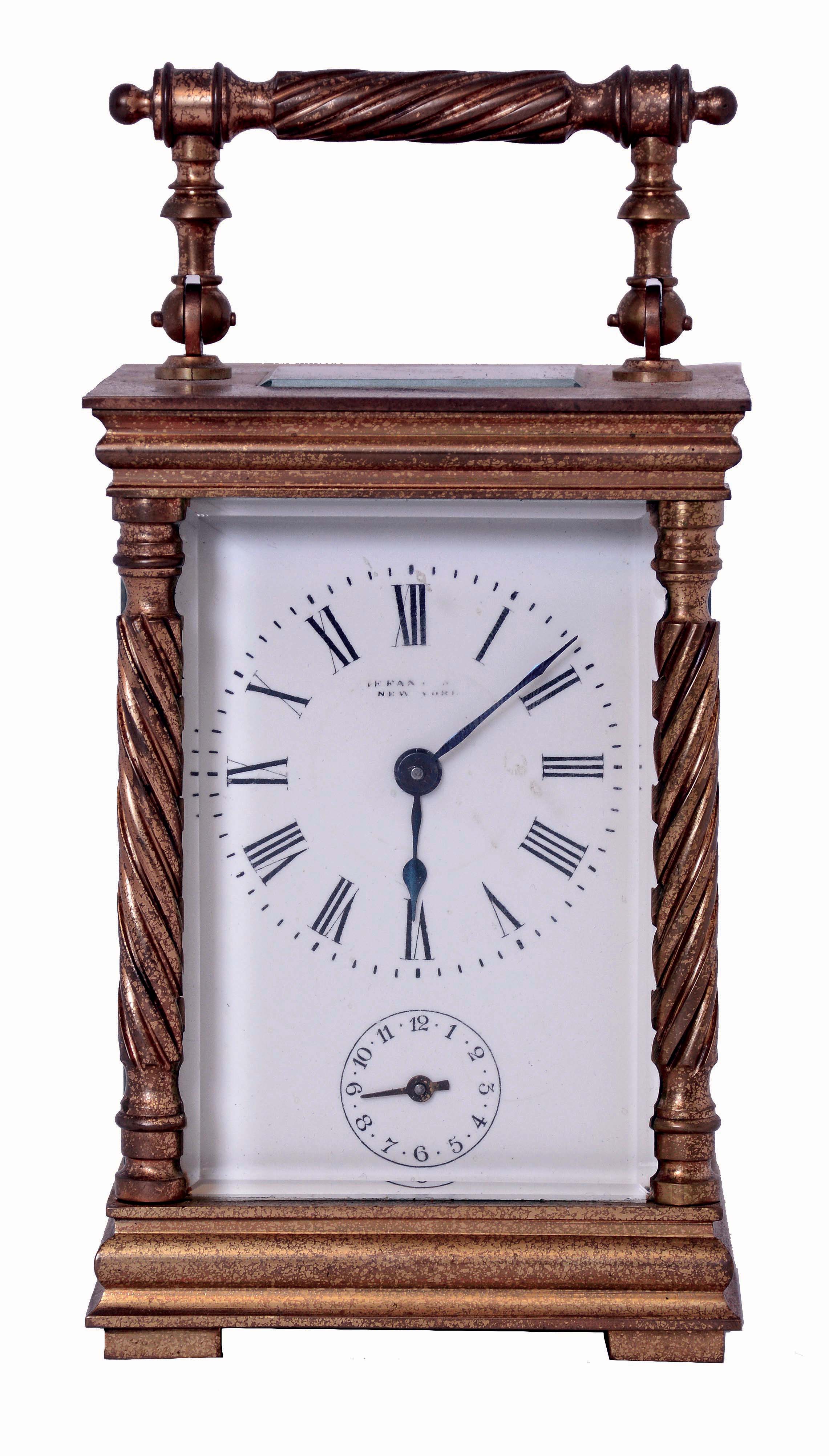 France, for Tiffany &amp; Co., carriage clock in a glazed, gilt brass case, with twist turned columns and handle, Roman numeral white enamel dial, blued steel hands, 8 days, time and alarm movement with lever platform, c1900, together with a leather covered outer case from a larger clock — Antique Clocks Price Guide