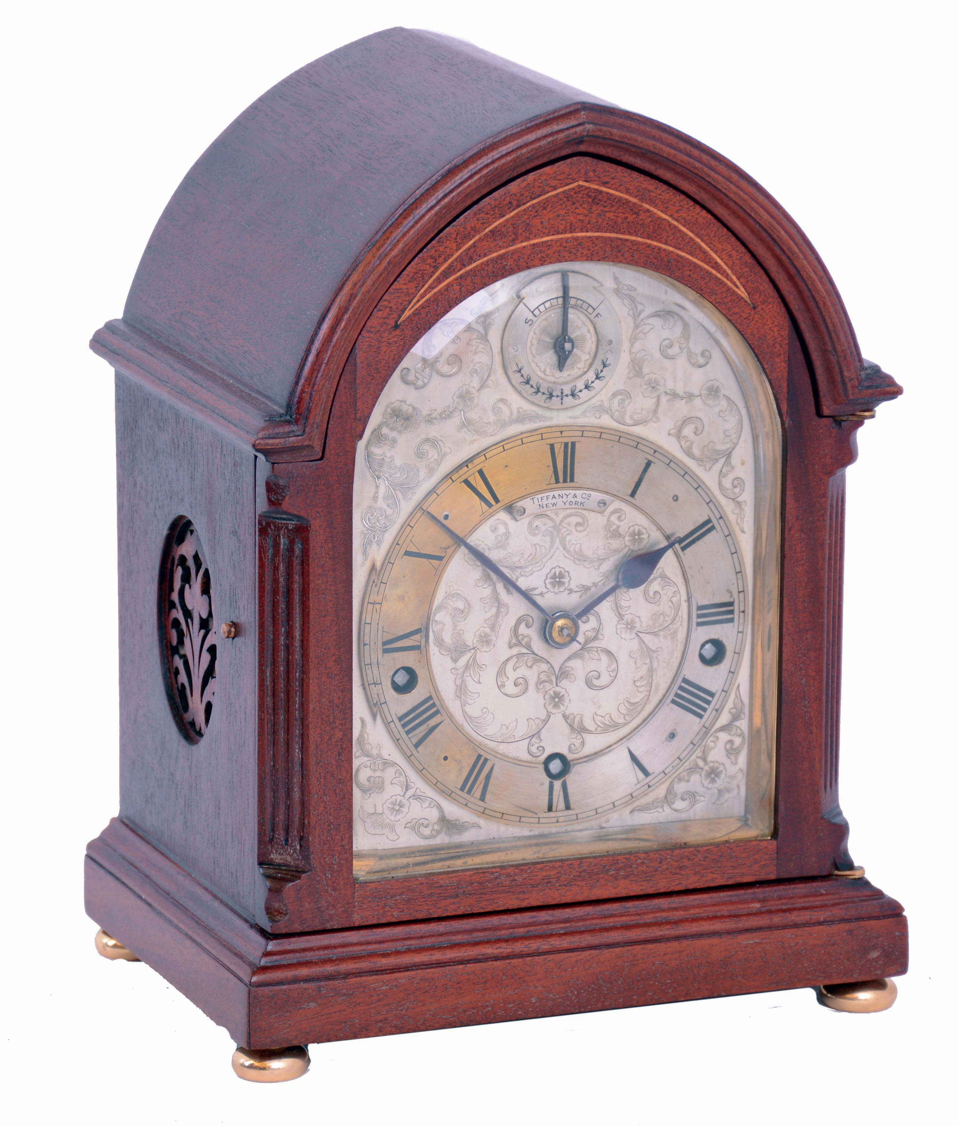 Clocks- 2 (Two) Bracket Chiming: (1) German oak, 8 days, time, strike and Westminster chime round top bracket clock, with subsidiary indicators for chime/silent and fast/slow adjustment, c1910 (2) J.J. Elliott, for Tiffany &amp; Co., New York, mahogany, 8 days, balance wheel bracket clock with Westminster chimes on coiled gongs, c1910 — Antique Clocks Price Guide