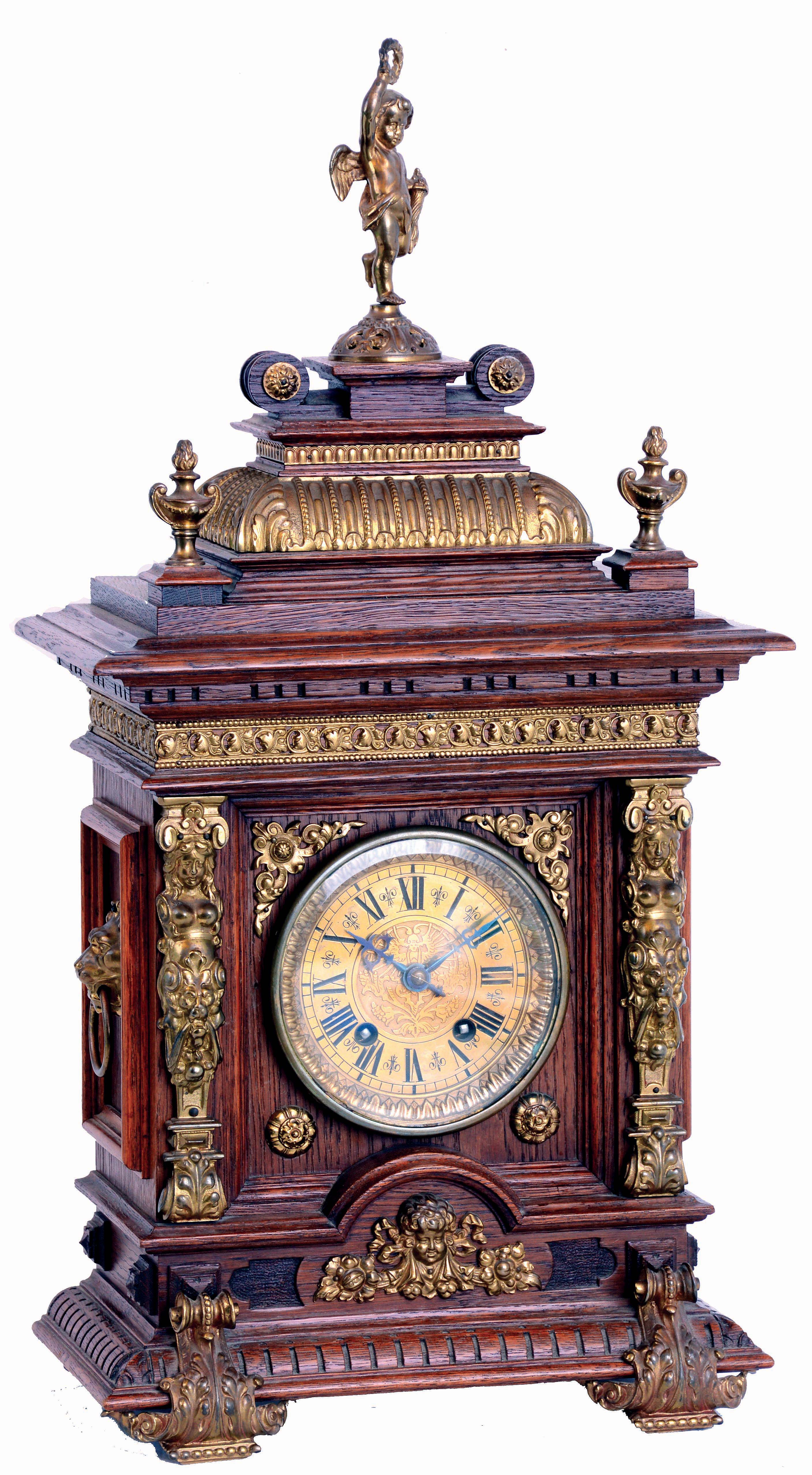 Lenzkirch, Germany, bracket clock, architectural oak case, heavily molded and with carved detail, mounted with a profusion of brass ornamentation including half caryatids, leaf and scroll feet, lion mask handles, and surmounted by a putto bearing a torch and wreath, Roman numeral brass dial, blued steel hands, 8 days time and strike movement, serial #616889, c1880 — Antique Clocks Price Guide
