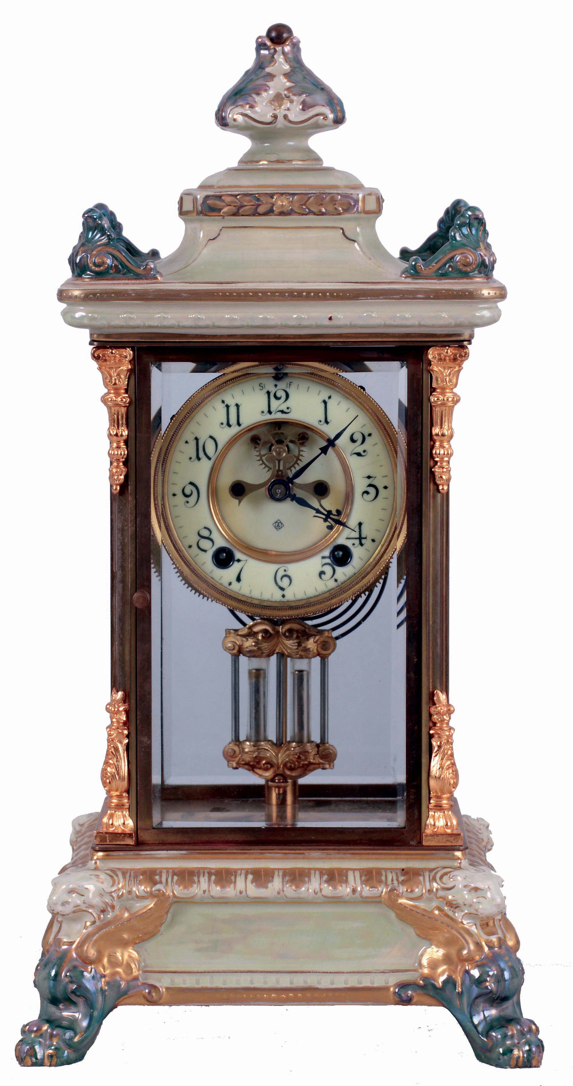 Ansonia Clock Co., New York, NY, "Crystal Regulator No. 6" in a gilt and brass case with a Royal Bonn top and base and a spring driven, 8 days, time and hour/half-hour strike movement with a visible escapement, c1906. — Antique Clocks Price Guide