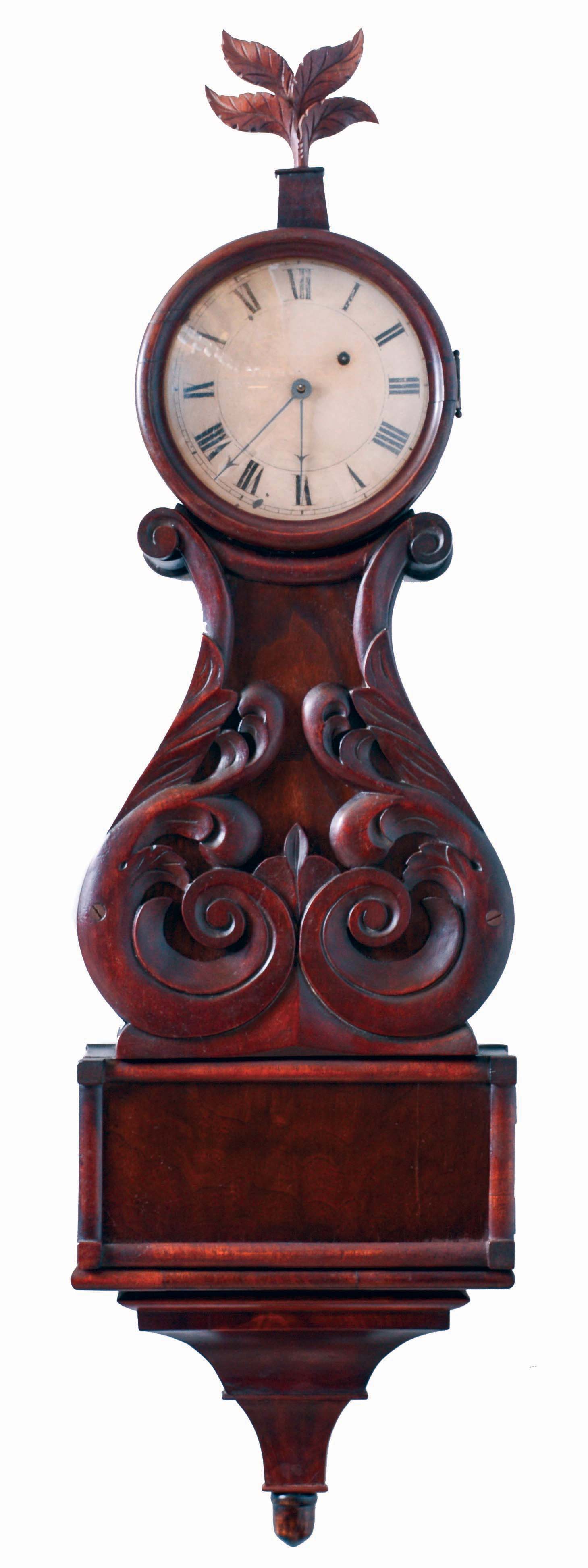 Boston area lyre clock, mahogany and mahogany veneer case with turned wooden bezel, leaf and scroll carved throat panel, bull nose molded lower door and with veneered bracket, carved leaf form finial, Roman numeral white painted sheet iron dial, 8 days, weight driven brass timepiece movement, c1830 — Antique Clocks Price Guide