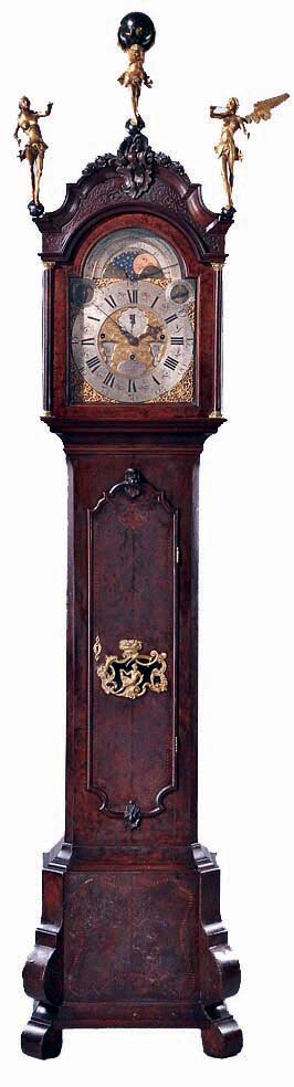 Pieter Thymen Gouda, Netherlands, Dutch musical tall case clock, 8 days, time, Dutch strike on a single bell and 12 tunes on 13 bells, three brass clad weight driven movement in a burled walnut veneer case with elephant feet, inlay and marquetry, cast brass cartouche revealing pendulum and Atlas and Angelic figures for finials. The composite brass dial has moon phase in arch and silvered song selector for twelve tunes, Roman numeral, silvered arcaded chapter ring with engraved center, silvered second's bit with date aperture at center, month and day of the week, c1760 — Antique Clocks Price Guide