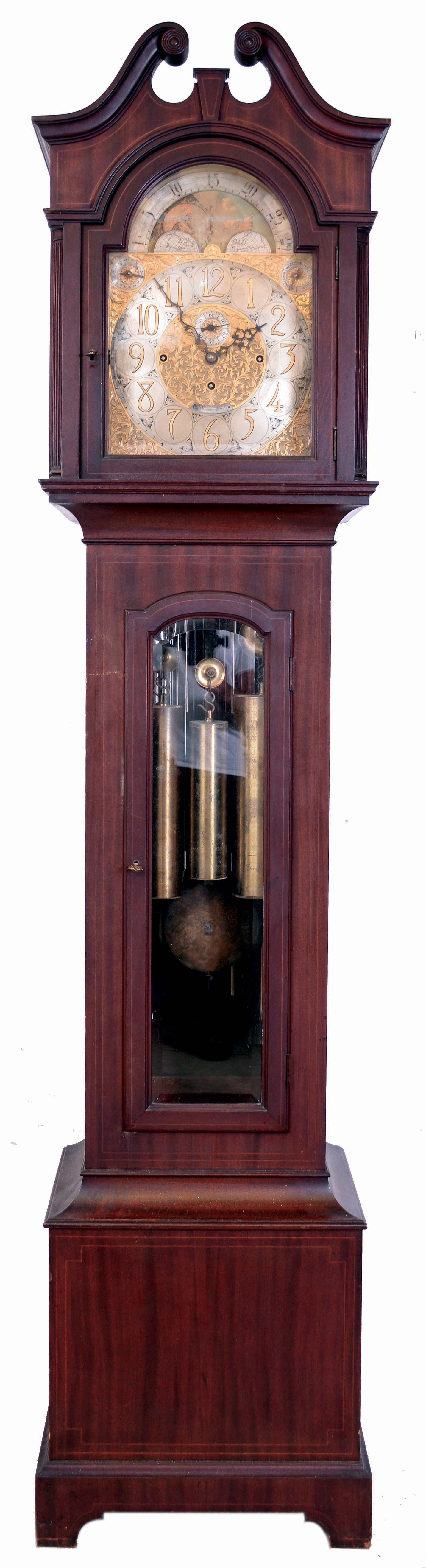 Tiffany &amp; Co., New York, 9 tube hall clock, 8 days, time, strike and chime, three weight driven movement by Elliot, London, playing three tunes (Westminster, Whittington and St. Michael's on tubes signed with patent date Dec. 4th 1906) in mahogany, string inlaid case on bracket base, broken arch hood with turned rosettes, beveled glass door in trunk and hood. The brass arched dial has a silvered chapter ring with applied brass numerals, surrounded by a finely engraved foliate mask, turned spandrels and dial center, moon phase, selection for chime or silent and tune, and second's bit, c1915 — Antique Clocks Price Guide