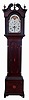 American tall clock, 8 days, time and strike, weight driven brass movement in an inlaid cherry case with broken arch top with carved rosettes, hollow carved corner columns and brass capitals, inlaid trunk with corner and center fans and inlaid plinth with corner and center fans and bell flower banding. Painted white dial with moon phase and calendar, c1810