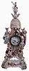 French, porcelain cased mantel clock in the rococo style, the pierced case has gilt and overglaze enamel decoration, the front with four female figures and an eagle with uncooperative legs, all surmounted by another female figure, standing on a winged globe, and resting on a matching porcelain base, Roman numeral white enamel dial with gilt Louis XV style hands, 8 days, pendule a Paris movement striking on a bell, and signed "Marti", c1880
