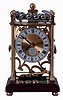 Dove Bazely Ltd., Cheltenham, England, Perpetuum clock, polished brass portico style case with mahogany base, Roman numeral silvered dial, 8 days, timepiece movement powered by a spring, and 24 steel balls, which drop from the rail on the case top onto the "ferris wheel" attached to the winding arbor behind the movement, with paperwork, c1986