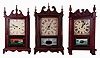 Clocks- 4 (Four): Daniel Pratt Jr., Reading, Mass., 30 hours, time, strike and alarm "groaner"-style wooden works, weight driven movement in a half column and scroll case, c1835; plus three 20th century reproductions- two pillar and scrolls (one New England Clock Co.) and one Asian carved clock.