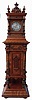 Lenzkirch, Germany, Symphonion Hall Clock, style No. 25 ST., walnut case with heavily molded base and standing on compressed ball feet, richly ornamented with veneers, turned elements and carving, mid section with door concealing the music player and disc, Arabic numeral silvered dial with fancy, piered brass hands, 14 day time and strike movement, which activates the music box following the hourly strike, serial #1148313, c1897