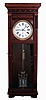 Waterbury Clock Co., Waterbury, Conn (attribution). "Regulator No. 7" variant, jeweler's regulator wall clock, 8 days, time only, weight driven Swiss movement with pinwheel escapement, three jar mercury pendulum and center sweep seconds in a cherry case with detailed carving around top and bottom, backboard and door with burled highlights, fan carved dial surround with a white enamel dial, c1890