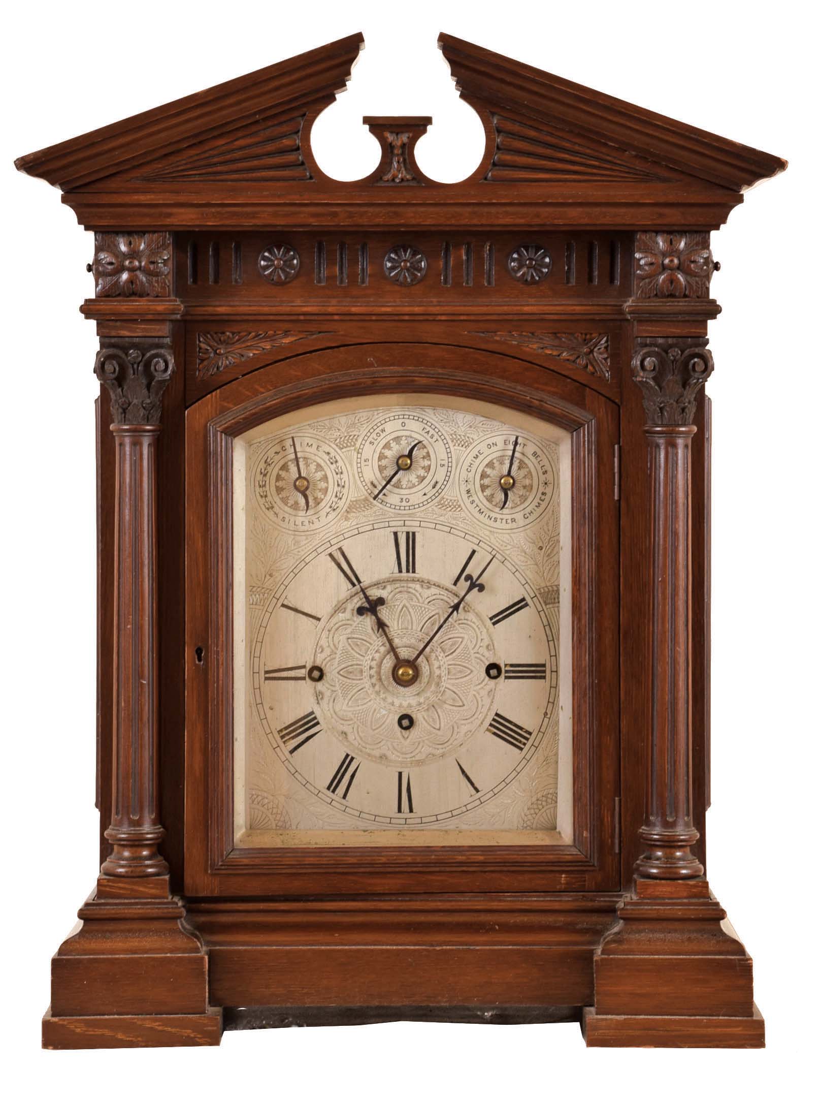 Germany, for the English market, quarter chiming bracket clock, architectural oak case with heavy, molded base, fluted columns with carved capitals, supporting a frieze with carved and applied ornament, and pitched pediment cornice, case sides with pierced wooden frets, finely engraved silvered dialwith Roman numeral chapter, and with chime and rating controls, blued steel hands, massive 8 day, three train fusee movement, chiming Westminster, or On Eight Bells at the quarters, and striking the hours on a large gong — Antique Clocks Price Guide