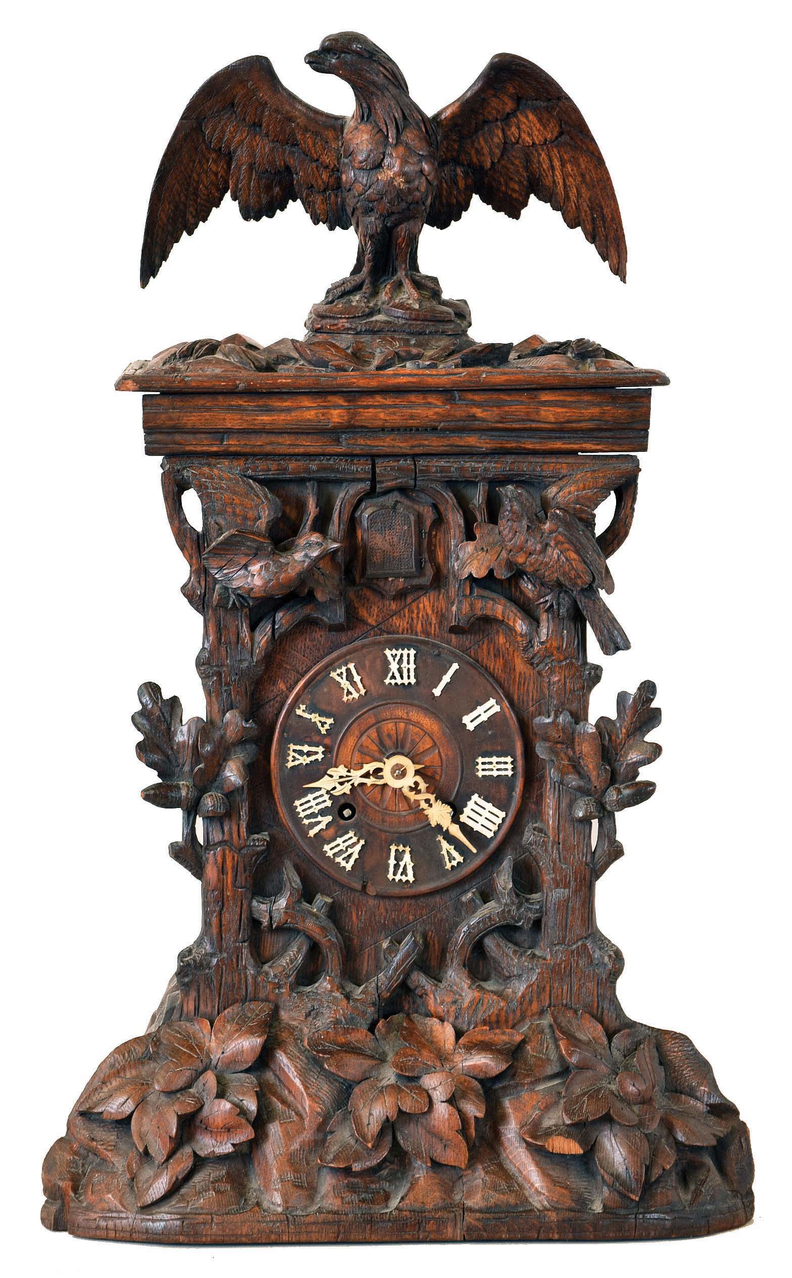 Shelf Cuckoo, carved oak case in the rustic style, the front with oak leaves and acorns, two birds, all surmounted by a large eagle, turned wooden dial with applied Roman numerals, carved bone hands, 8 day, brass time and strike with going barrels and count wheel striking, — Antique Clocks Price Guide