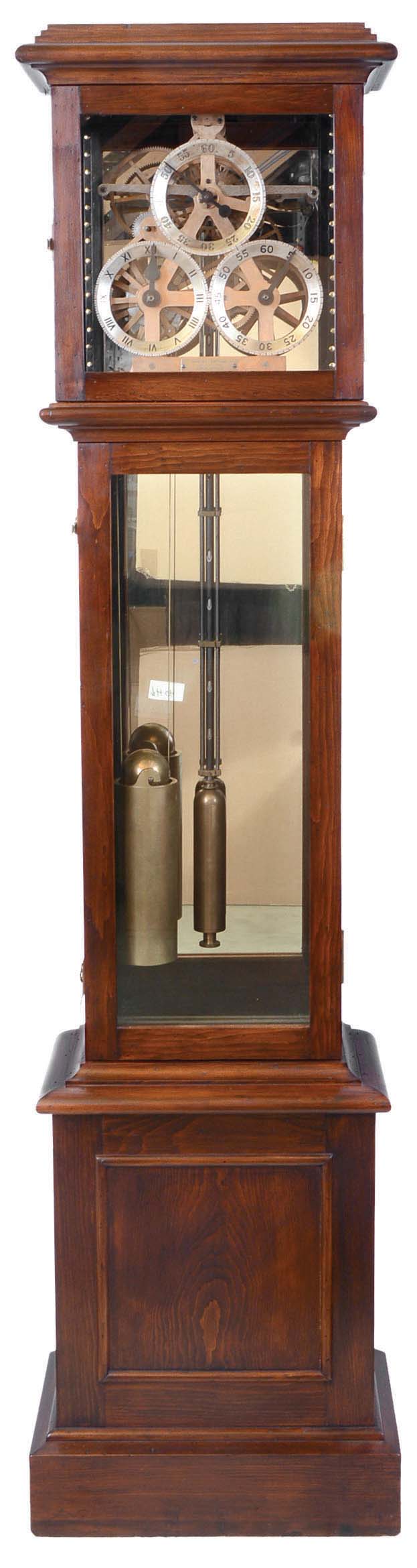 James Arthur, The Arthur Company, New York, NY for his son Daniel Arthur, "Remontoire Regulator No. 1 with Deadbeat Escapement" floor standing astronomical regulator, 8 days, time only, weight driven movement with a remontoir wheel and carriage that lifts once per minute, providing power to the escape wheel The skeletonized damascened movement is stamped in several places "1" has a perforated center tube surrounding a temperature compensating steel, brass and aluminum pendulum rod and is housed in a pine case with mirrored back. The astronomical dial has three silvered chapter rings for seconds, minutes and hours, below which is a presentation plaque to James Arthur's son Daniel and dated June 13th, 1901 — Antique Clocks Price Guide