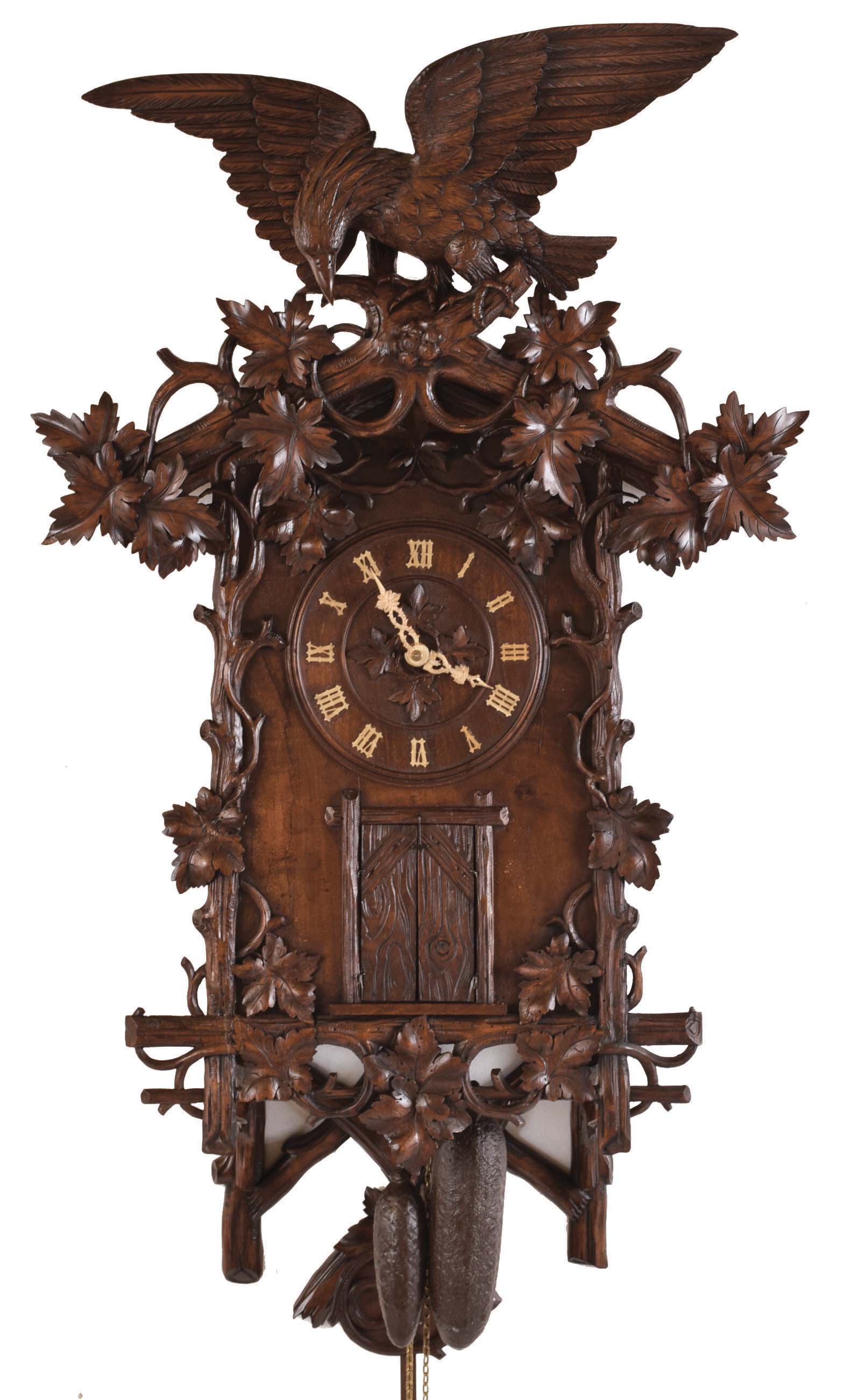Emilian Wehrle, Germany, hanging Trompeteruhren, or Trumpeter Clock, walnut case with rustic carving, vines and leaves, the top with a large carved eagle, and the bottom also with rustic ornament, the trumpeter concealed behind plank doors, below the turned wooden dial with applied Roman numerals and carved bone hands, the bellows, wind chest, and pipes mounted above the two train, 30 hour movement with pierced brass plates, carved pendulum, and cast iron weights — Antique Clocks Price Guide