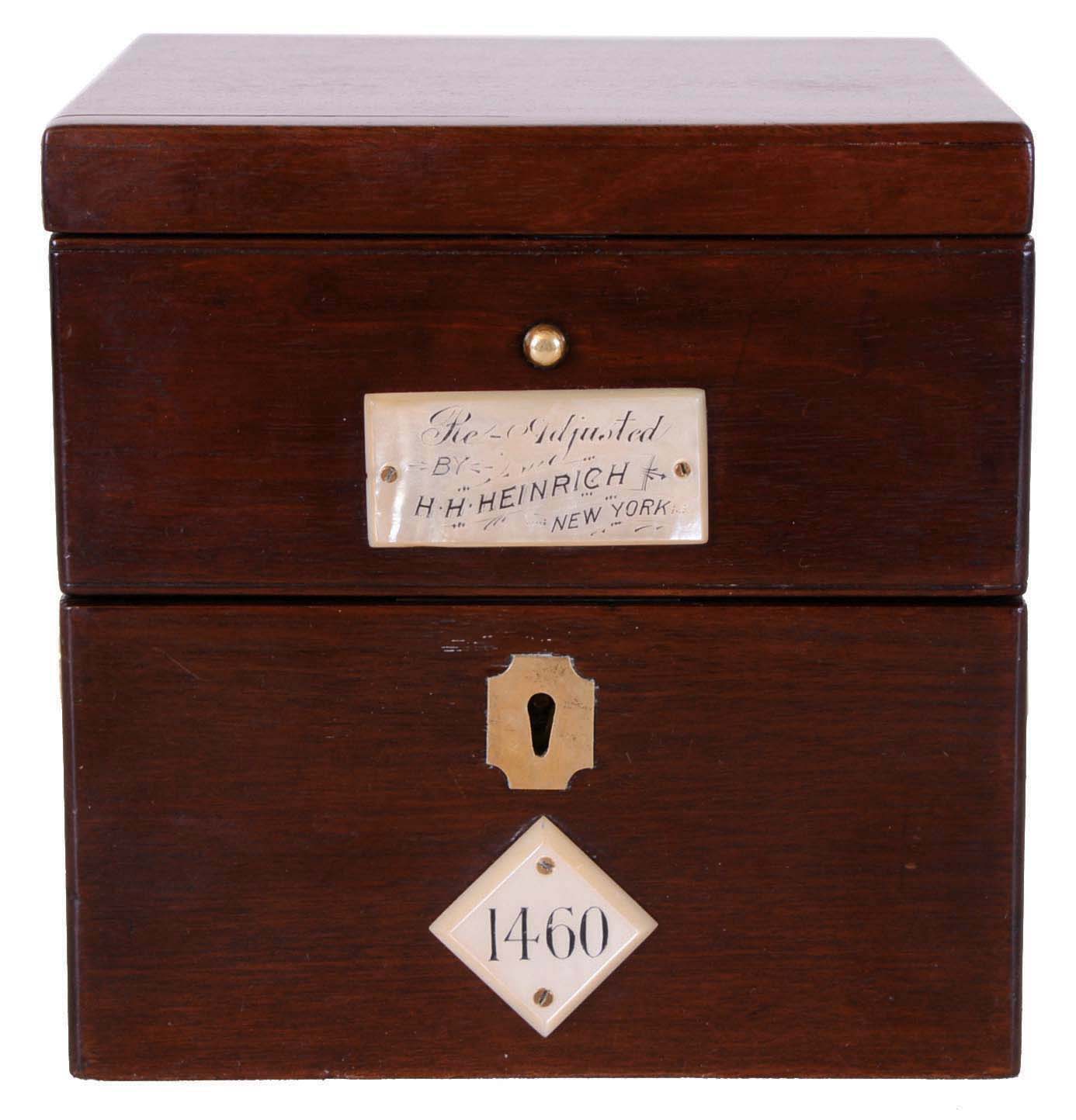 Parkinson &amp; Frodsham, Change Alley, London, 2 day marine chronometer, small gilt plate fusee movement with spotting, spring detent escapement, and chronometer balance with blued steel helical hairspring, silvered Roman numeral dial with wind indicator, blued steel spade and poker hands, screw bezel with flat beveled glass, lacquered brass tub in gimbals, with inner shock proof tub containing movement, all in a mahogany box with brass hardware, the front with mother of pearl plaques, one marked "Re Adjusted by H. H. Heinrich New York", the other with the chronometer number "1460",with original numbered winding key, 6 1/2" x 6 1/2" x 6 1/2", c 1825 — Antique Clocks Price Guide